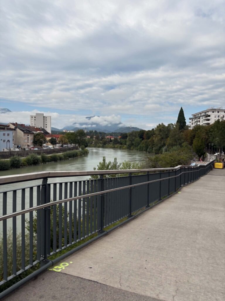 Villach arcai: a nyugodt Drau-part és a vidám, színes ernyőkkel díszített belvárosi utca.